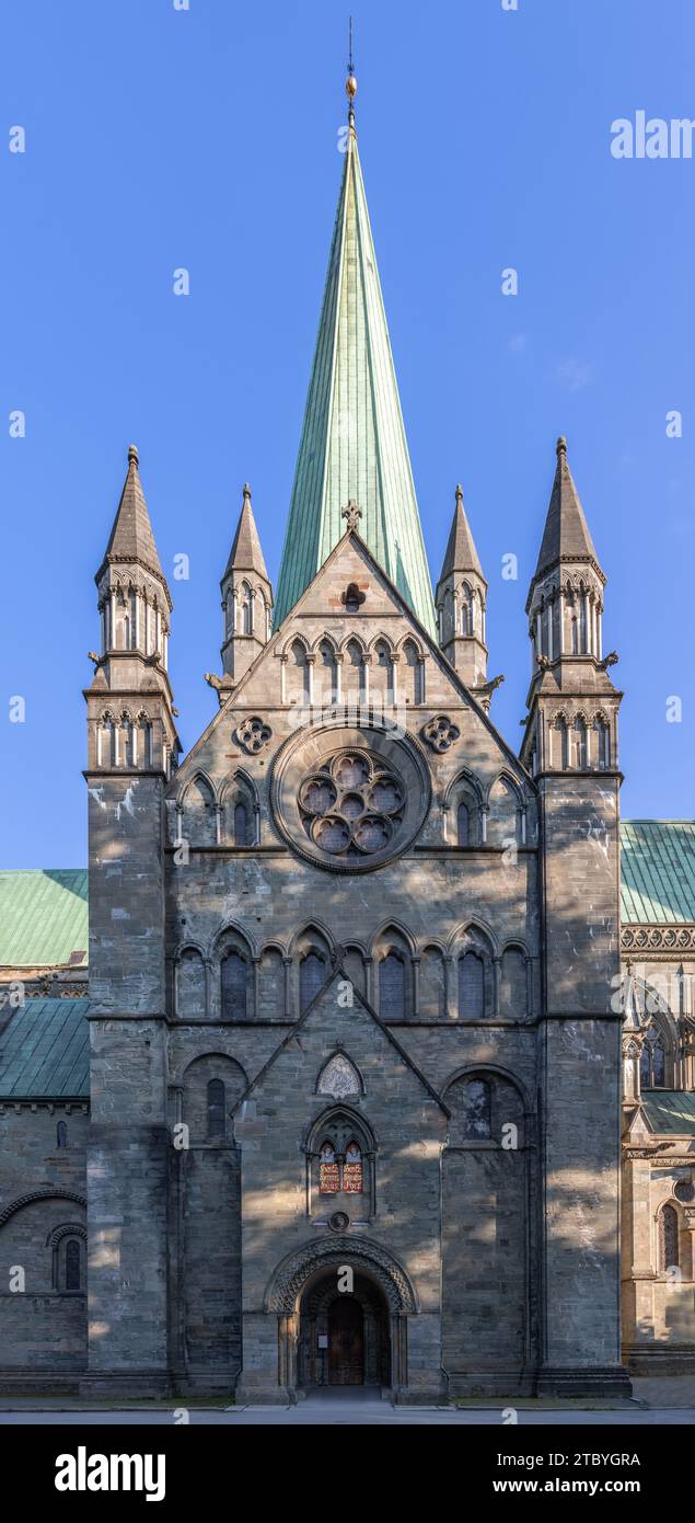 Ein vertikales Foto, das den Haupteingang der Nidaros Kathedrale (Nidarosdomen) in Trondheim, Norwegen, vor dem Hintergrund eines klaren blauen Himmels festnimmt Stockfoto