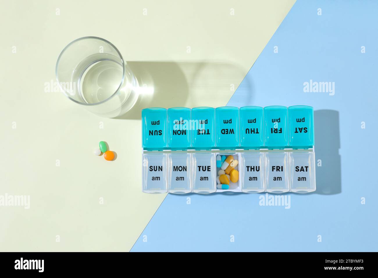 Arzneimittelkonzept; nehmen Sie die Medizin jeden Tag pünktlich ein. Verschlossenes Bild von Pillen-Kapseln im Pillen-Organizer Stockfoto