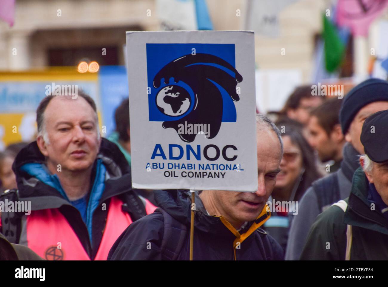London, England, Großbritannien. Dezember 2023. Ein Demonstrant hält ein ADNOC-Plakat. Klimaaktivisten versammelten sich vor dem Hauptquartier von BP in Zentral-London, um gegen die Übernahme der COP28 durch Ölkonzerne zu protestieren und für Klimagerechtigkeit zu plädieren. (Kreditbild: © Vuk Valcic/ZUMA Press Wire) NUR REDAKTIONELLE VERWENDUNG! Nicht für kommerzielle ZWECKE! Stockfoto London, England, Großbritannien. Dezember 2023. Ein Demonstrant hält ein ADNOC-Plakat. Klimaaktivisten versammelten sich vor dem Hauptquartier von BP in Zentral-London, um gegen die Übernahme der COP28 durch Ölkonzerne zu protestieren und für Klimagerechtigkeit zu plädieren. (Kreditbild: © Vuk Valcic/ZUMA Press Wire) NUR REDAKTIONELLE VERWENDUNG! Nicht für kommerzielle ZWECKE! Stockfoto