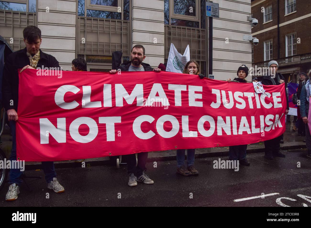 London, Großbritannien. Dezember 2023. Die Demonstranten halten während der Demonstration ein Banner mit der aufschrift "Klimagerechtigkeit nicht Kolonialismus". Klimaaktivisten versammelten sich vor dem Hauptquartier von BP in Zentral-London, um gegen die Übernahme der COP28 durch Ölkonzerne zu protestieren und für Klimagerechtigkeit zu plädieren. (Foto: Vuk Valcic/SOPA Images/SIPA USA) Credit: SIPA USA/Alamy Live News Stockfoto
