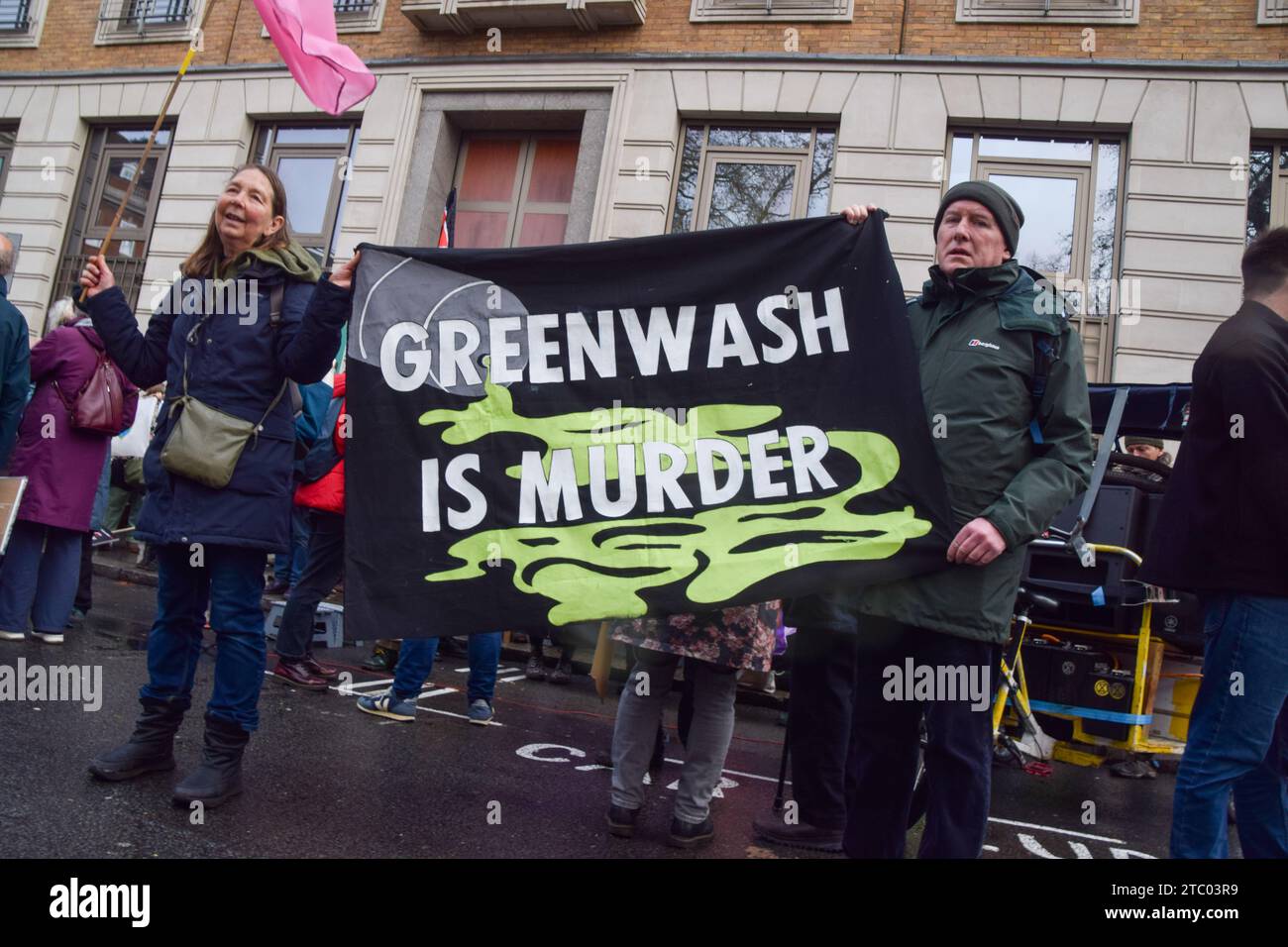 London, Großbritannien. Dezember 2023. Die Demonstranten halten während der Demonstration ein Banner mit der aufschrift „Greenwash is Mord“. Klimaaktivisten versammelten sich vor dem Hauptquartier von BP in Zentral-London, um gegen die Übernahme der COP28 durch Ölkonzerne zu protestieren und für Klimagerechtigkeit zu plädieren. (Foto: Vuk Valcic/SOPA Images/SIPA USA) Credit: SIPA USA/Alamy Live News Stockfoto