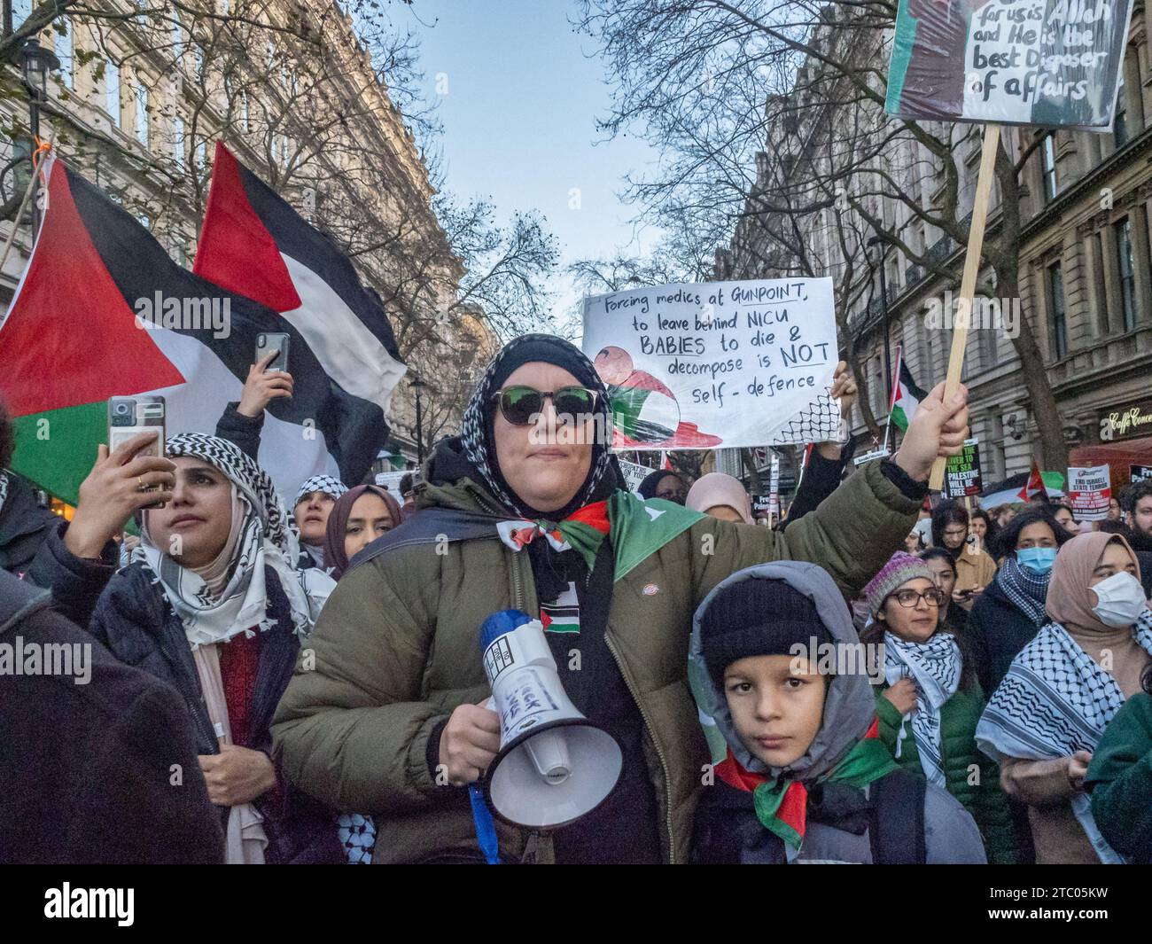 London, Großbritannien. Dezember 2023. Hunderttausende marschieren in London, um einen vollständigen Waffenstillstand in Gaza zu fordern, wo israelische Truppen über 17.000 Menschen getötet haben, darunter mehr als 7.000 Kinder. Bombenanschläge haben humanitäre Hilfe und medizinische Behandlung unmöglich gemacht, und weit verbreitete Todesfälle durch Krankheiten und Hunger scheinen jetzt unvermeidlich zu sein. Die Demonstranten fordern ein Ende des Völkermords und eine politische Lösung, um Palästina Frieden und Gerechtigkeit nach dem Völkerrecht zu bringen. Peter Marshall/Alamy Live News Stockfoto