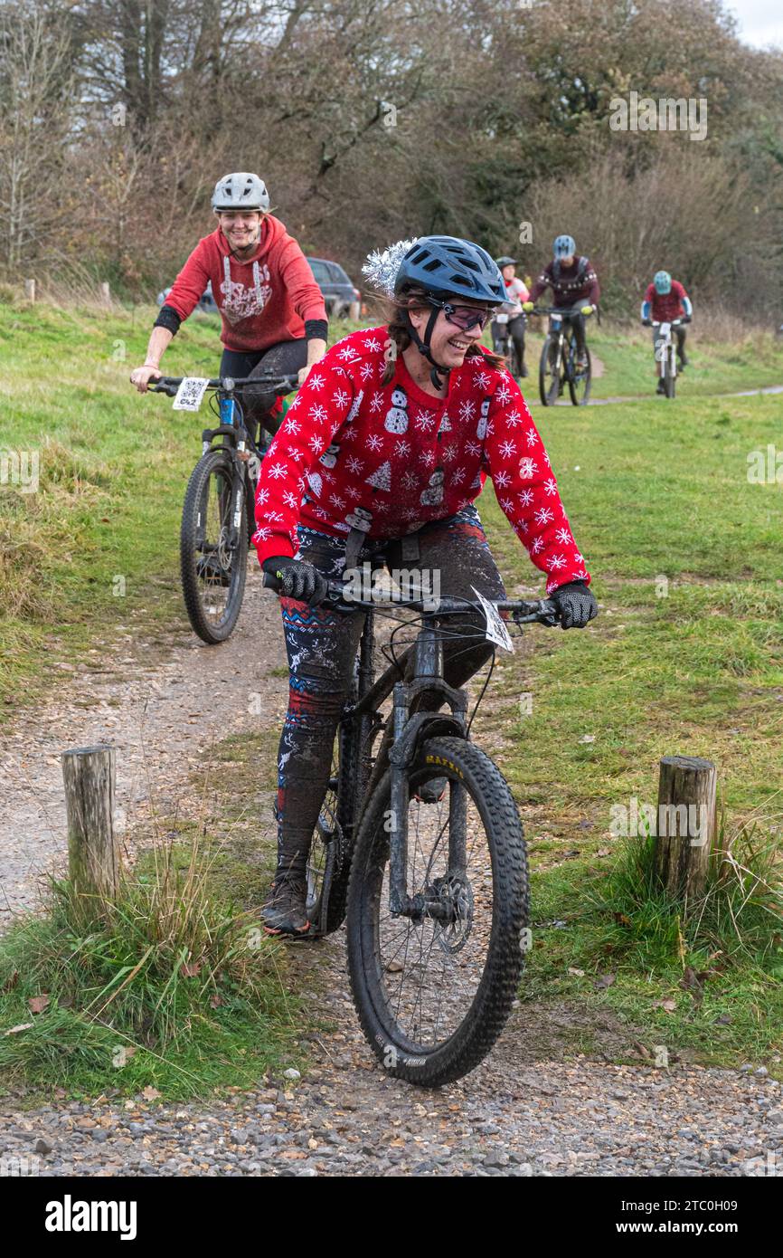 Dezember 2023. Teilnehmer, die ihre Mountainbikes beim Dirty Santa MTB Trail Cycling Event in den Surrey Hills, England, Großbritannien, fahren. Viele der Radfahrer trugen Weihnachtskostüme und wurden auf der Offroad-Route durch die Surrey Hills Area of Outstanding Natural Beauty sehr matschig. Stockfoto