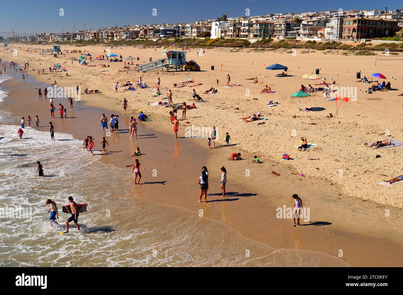 Strandbesucher genießen die Sommersonne entlang der Küste in Manhattan Beach, Kalifornien Stockfoto
