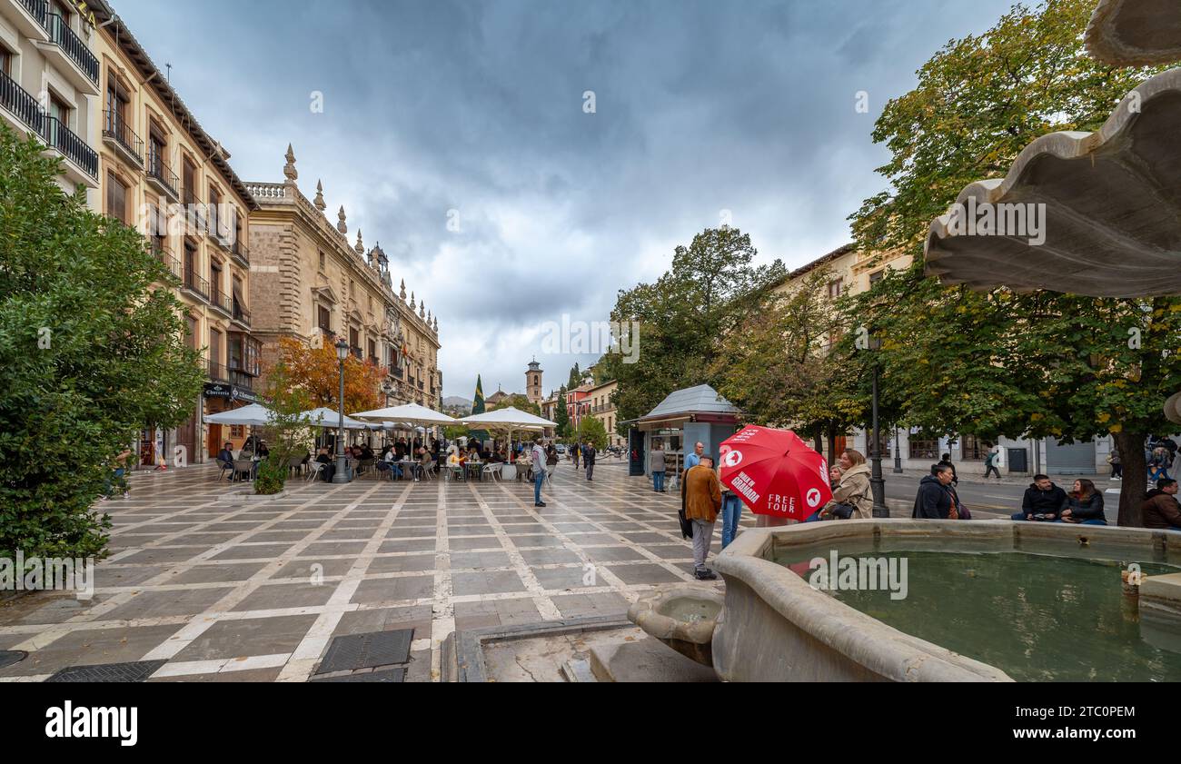 Granada, Spanien; 4. November 2023: Weitwinkelblick auf die beliebte Plaza Nueva und die Alhambra im Hintergrund (Granada, Spanien) mit Touristen Stockfoto