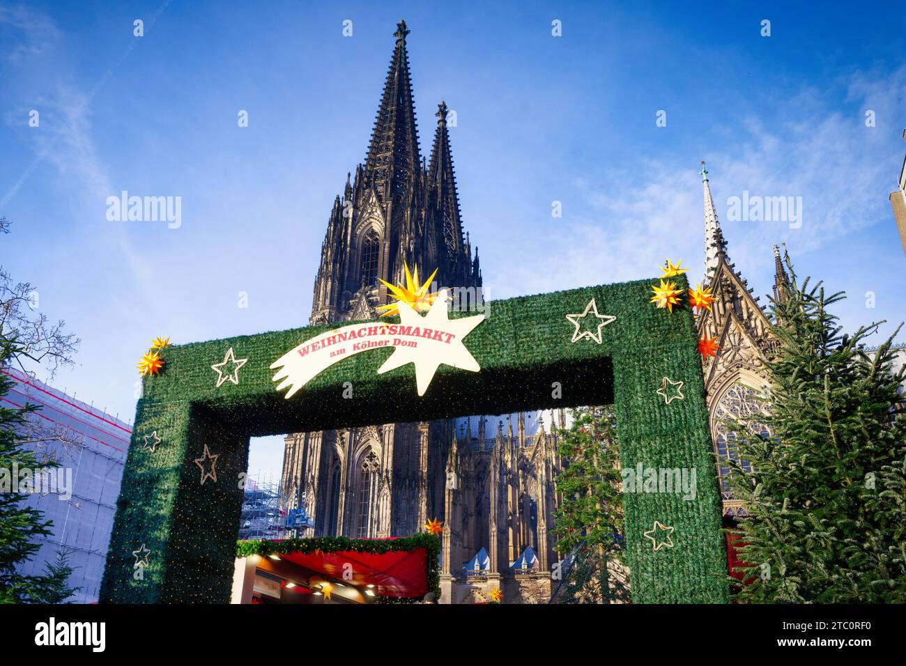 Eingangsportal zum größten kölner weihnachtsmarkt am Dom bei Tageslicht mit dem Dom im Hintergrund Stockfoto