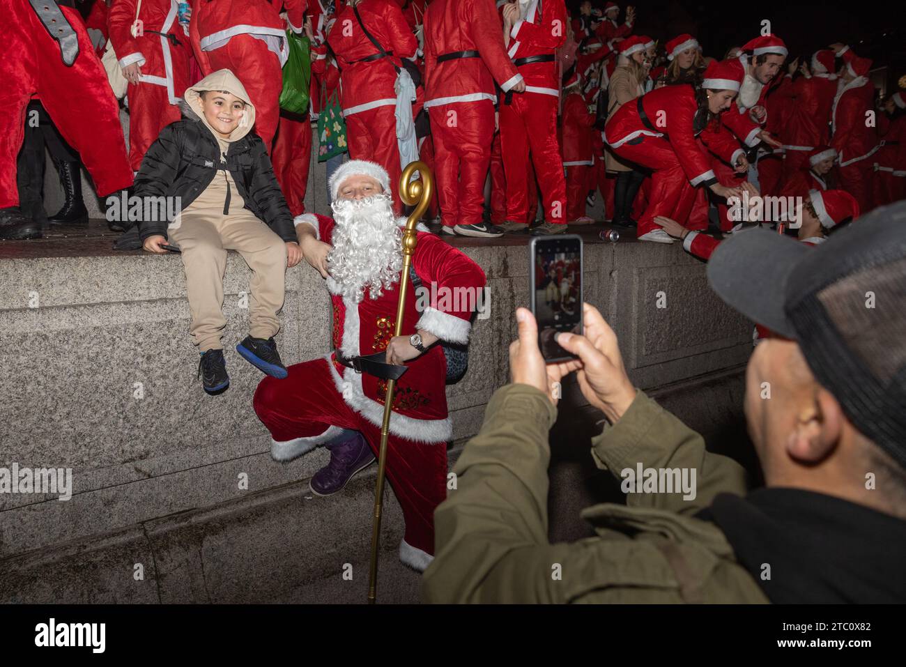 London, Großbritannien. DEZEMBER 2023. Ein kleines Kind macht ein Selfie mit dem Hauptmann Santa Con 2023. Credit Milo Chandler/Alamy Live News Stockfoto