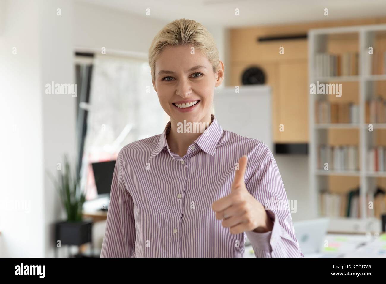 Porträt einer lächelnden Kundin zeigt Daumen nach oben Stockfoto