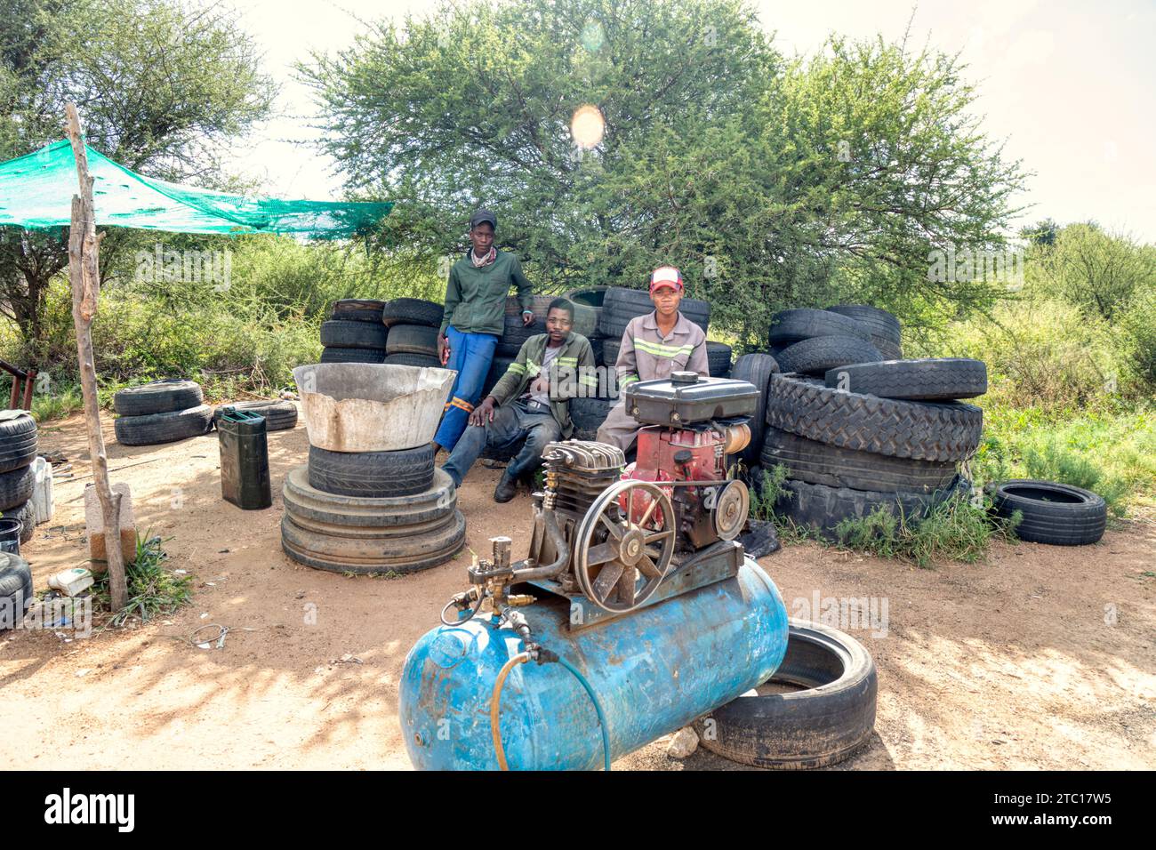 afrikanischer Unternehmer, der Reifen am Straßenrand repariert Stockfoto