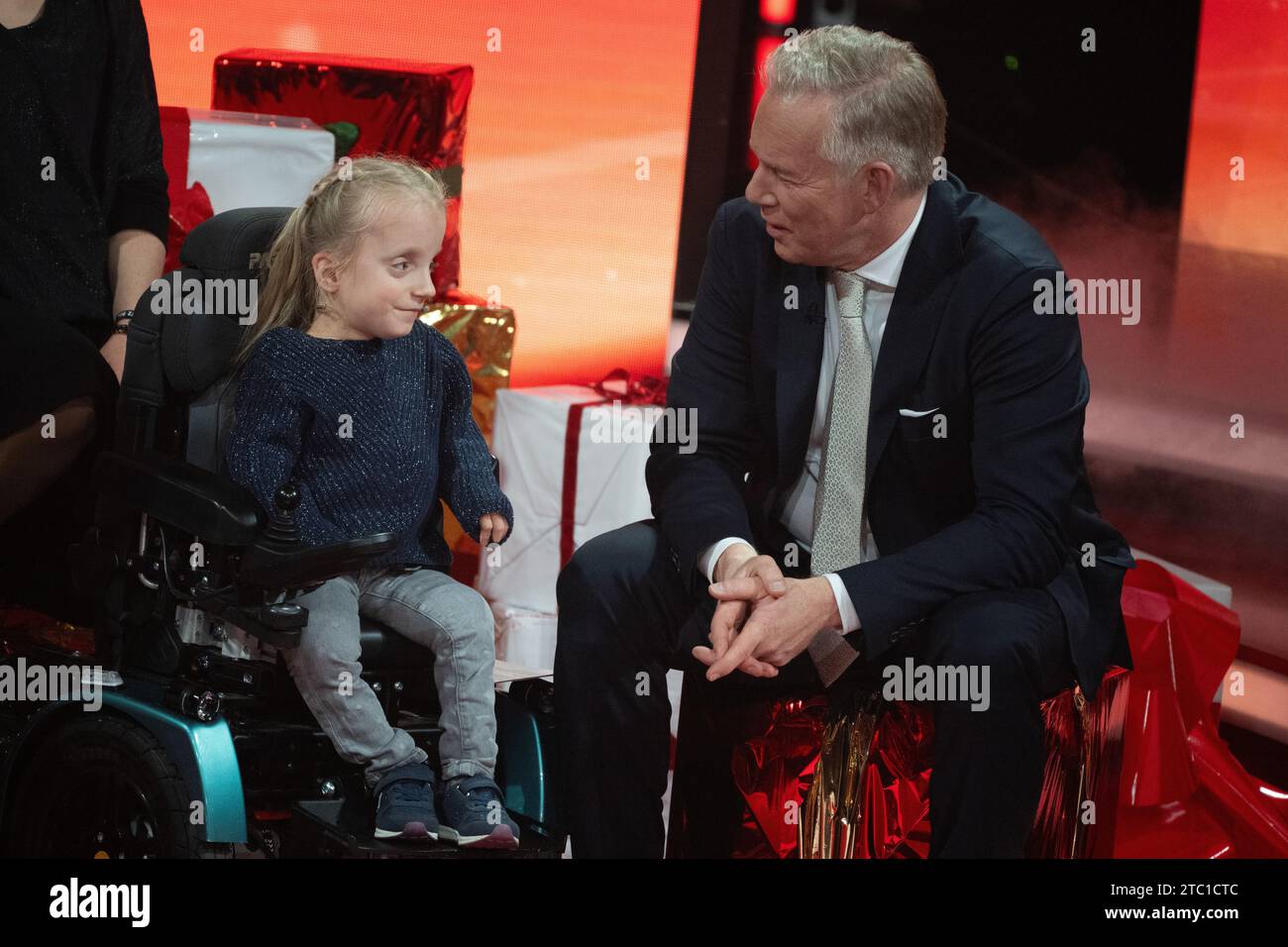 Berlin, Deutschland. Dezember 2023. Moderator Johannes B. Kerner spricht während der TV-Spendengala „Ein Herz für Kinder“ mit der zehnjährigen Klara, die an einer Knochenerkrankung leidet. Quelle: Sebastian Gollnow/dpa/Alamy Live News Stockfoto