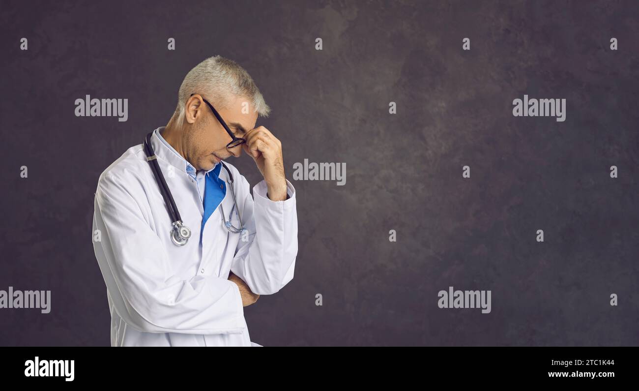 Ein belasteter männlicher Arzt denkt an eine Problemlösung Stockfoto