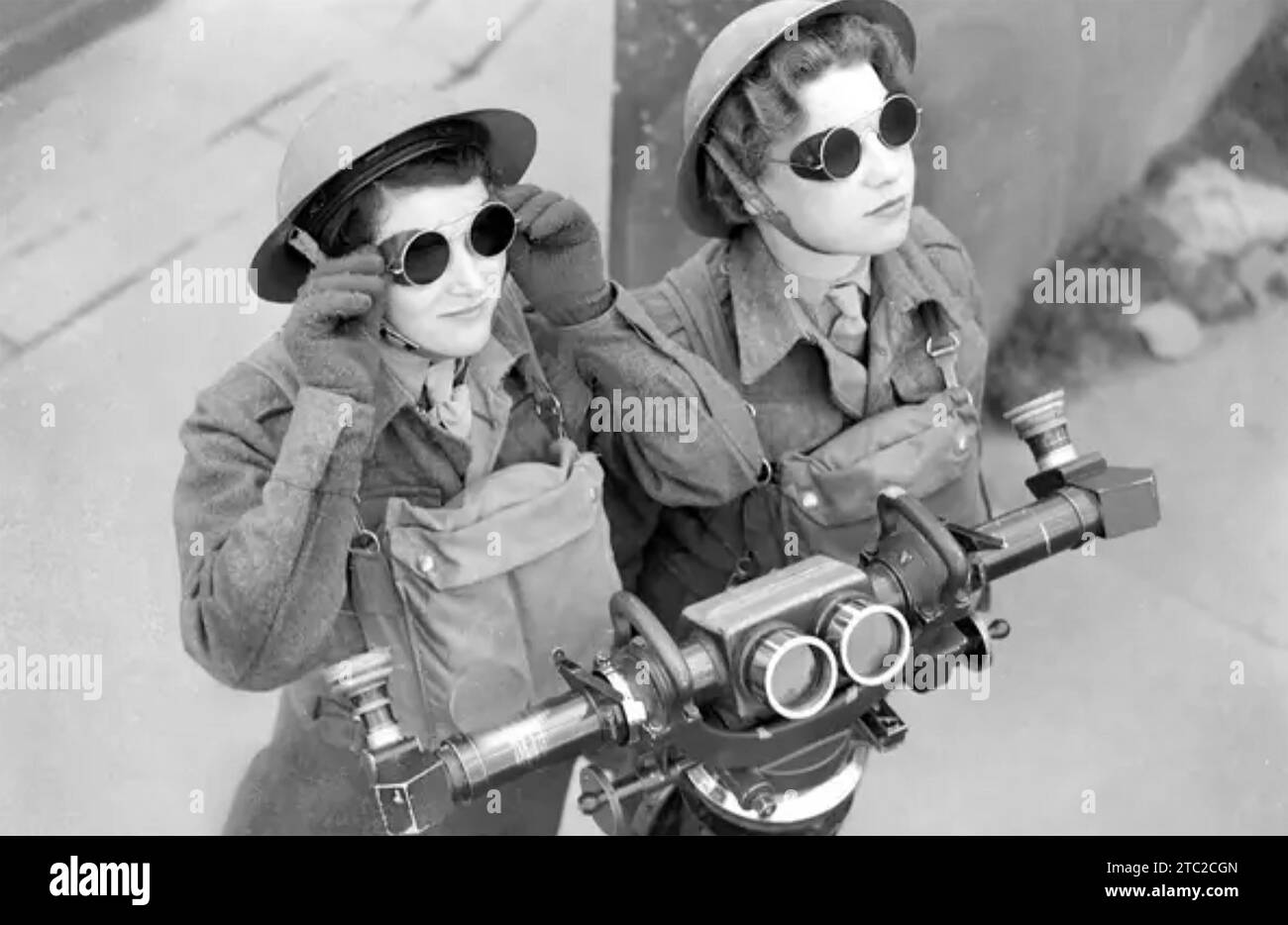 ATS-Beobachter (Auxiliary Territory Service), die 1940 deutsche Flugzeuge beobachten. Sie tragen Gasmasken und bestimmen mit dem Fernmessgerät vor ihnen Höhe und Richtung. Stockfoto