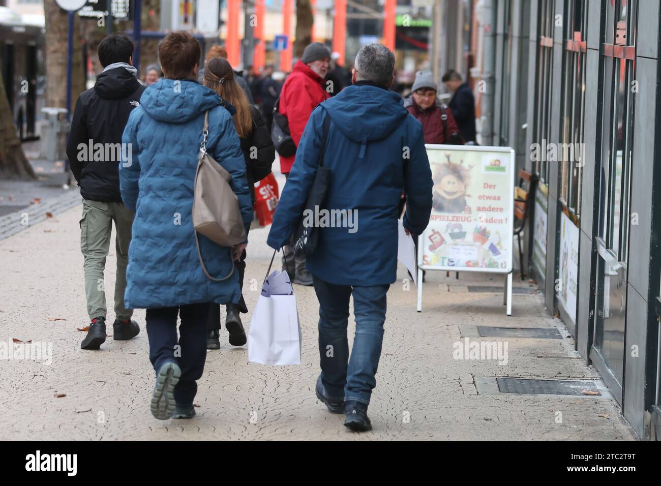 Jena, Deutschland. Dezember 2023. Passanten mit Einkaufstaschen laufen durch das Stadtzentrum. Am zweiten Adventssonntag nutzen zahlreiche Menschen die Einkaufsmöglichkeit. Quelle: Bodo Schackow/dpa/Alamy Live News Stockfoto