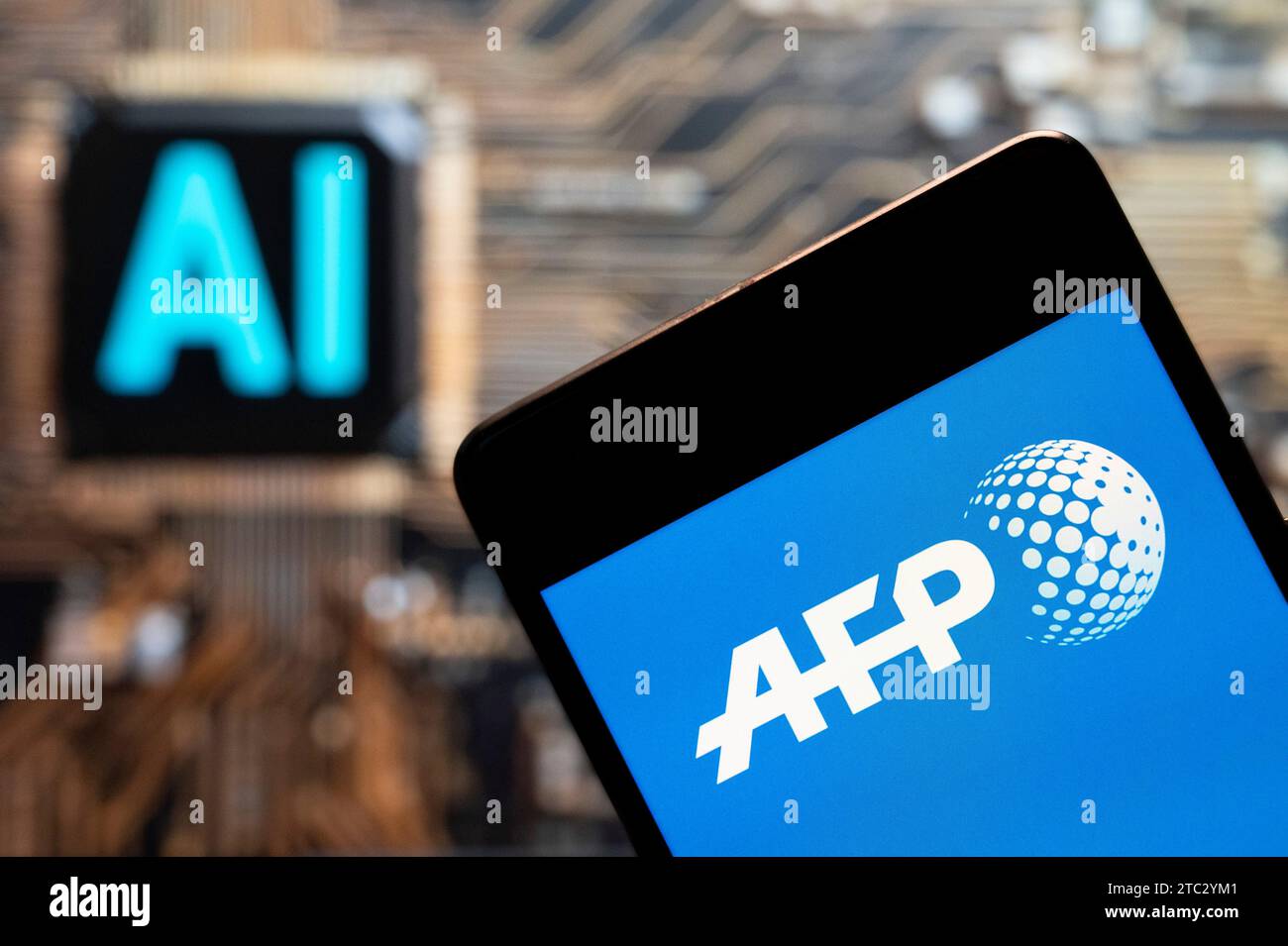 In dieser Fotoabbildung wird das Logo der internationalen Nachrichtenagentur Agence France Presse (AFP) auf einem Smartphone mit einem Chip für künstliche Intelligenz (KI) und einem Symbol im Hintergrund angezeigt. Stockfoto