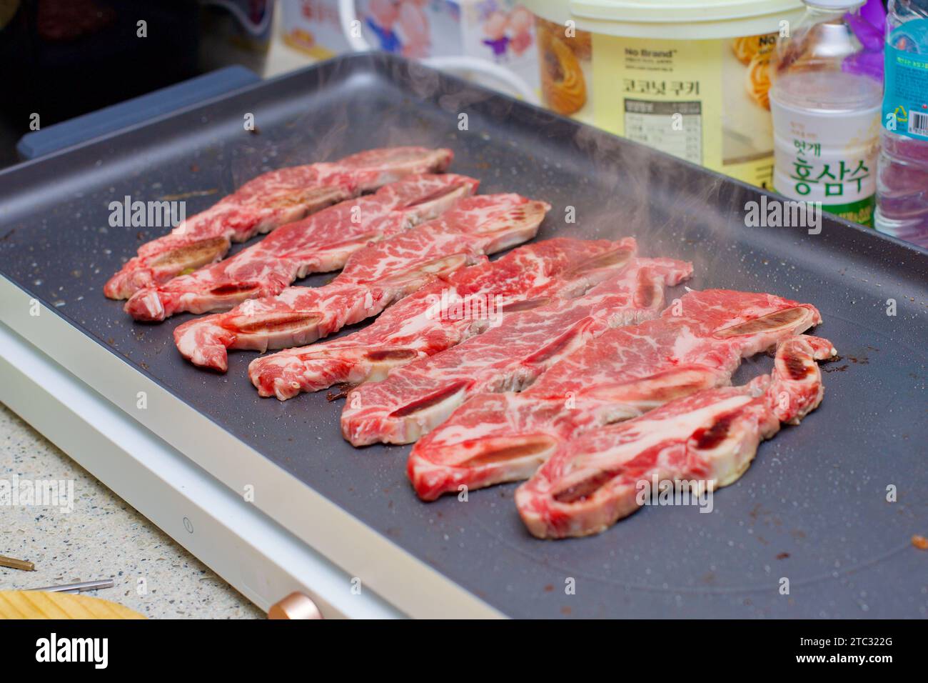 Saftige Fleischscheiben sickern verführerisch in einer heißen Pfanne und fangen das Wesen eines köstlichen kulinarischen Erlebnisses ein. Stockfoto