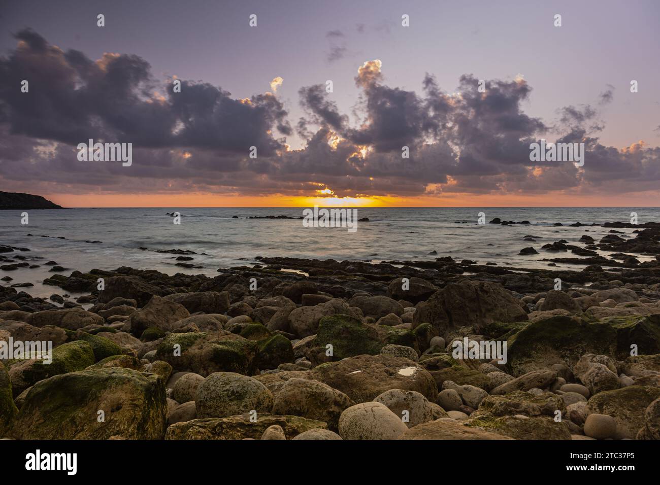 Lebendiger Sonnenuntergang über dem Horizont des Ozeans mit einer felsigen Küste in Sao Martinho do Porto, Portugal Stockfoto