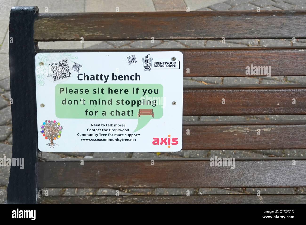 Das Schild mit der Chatty-Bank ist auf der Parkbank in einem Vorstadtzentrum angebracht, um Gespräche mit allen zu führen, die mit Brentwood Essex England UK sprechen Stockfoto