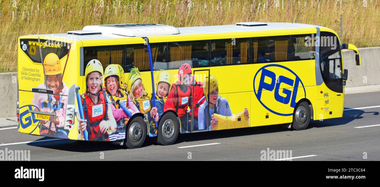 Werbegrafiken für Abenteuerreisen für Schulkinder auf der Seite und Rückseite des Reisebusses auf der Autobahn M25 Essex England UK Stockfoto