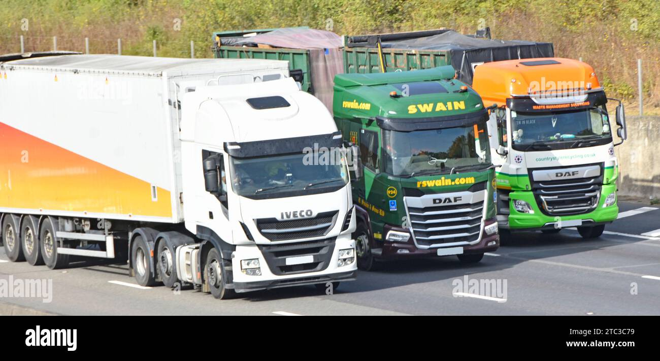 Nahaufnahme einer Gruppe von drei Spediteuren, die LKW-Lastkraftwagen in der Lieferkette betreiben, die die vierspurige M25-Autobahn überqueren England Großbritannien Stockfoto