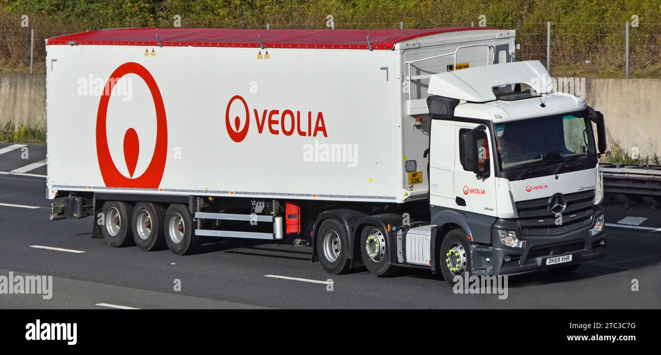 Veolia Environmental Services Rotes Markenlogo weißer Mercedes-Lkw mit schwerem Sattelauflieger und Sattelanhänger auf der M25-Autobahn in Großbritannien Stockfoto