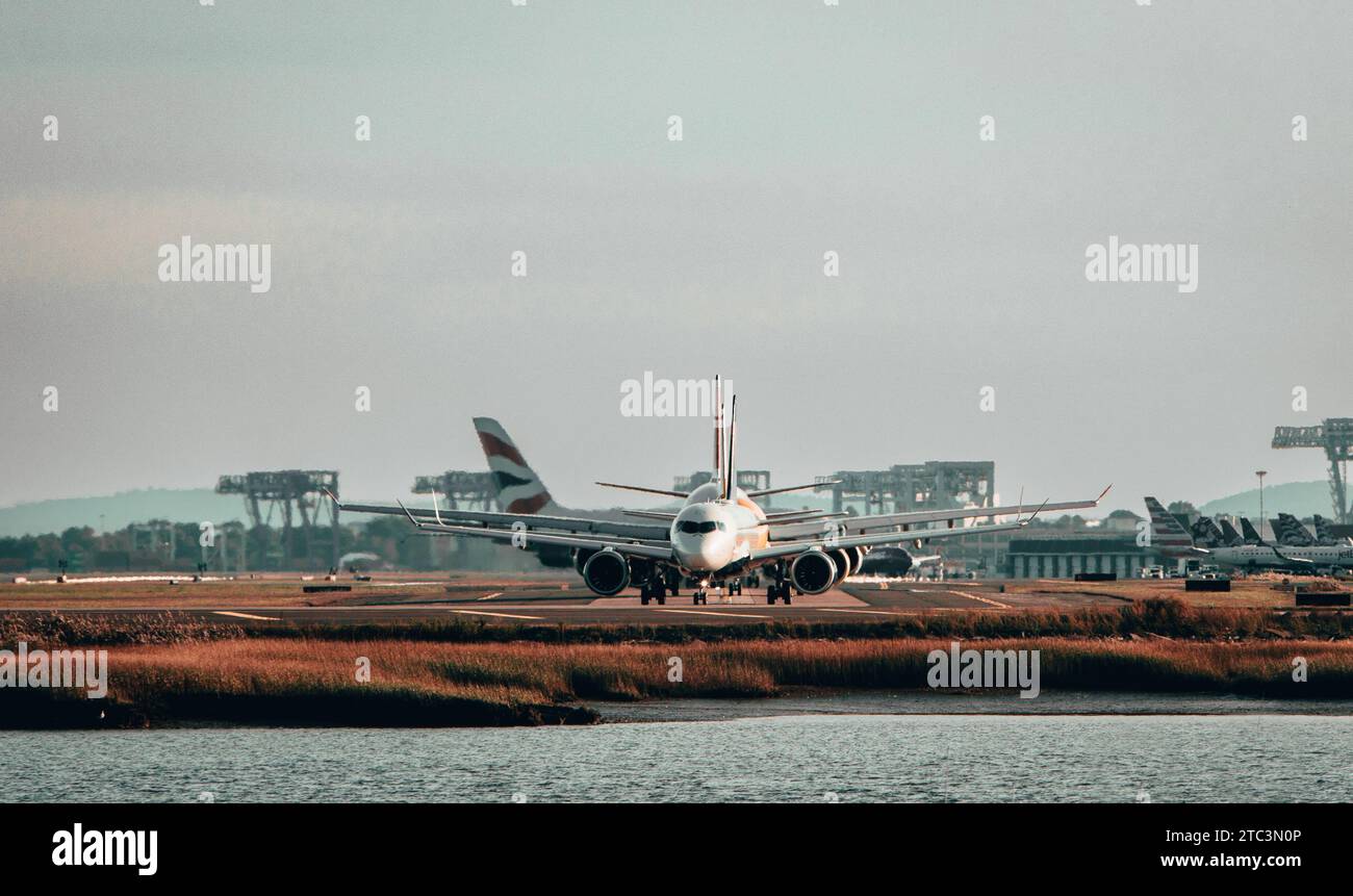 Ein kommerzielles Flugzeug ist dabei, von einer Start- und Landebahn des Flughafens aus zu starten, dessen Fahrwerk sichtbar nach oben eingezogen ist Stockfoto