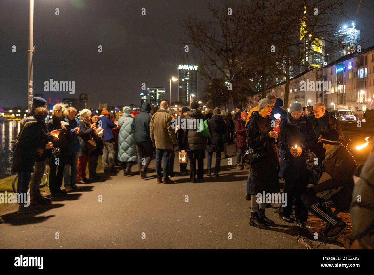 10. Dezember 2023, Hessen, Frankfurt/Main: Menschen nehmen an einer Lichterkette gegen Antisemitismus Teil. Frankfurts Kulturführer fordern eine Lichterkette entlang des Mainufers. Die katholische Rabanus-Maurus-Akademie, die Evangelische Akademie und zahlreiche andere kulturelle Einrichtungen der Stadt gehören zu den Sponsoren der Kampagne. Foto: Helmut Fricke/dpa Stockfoto