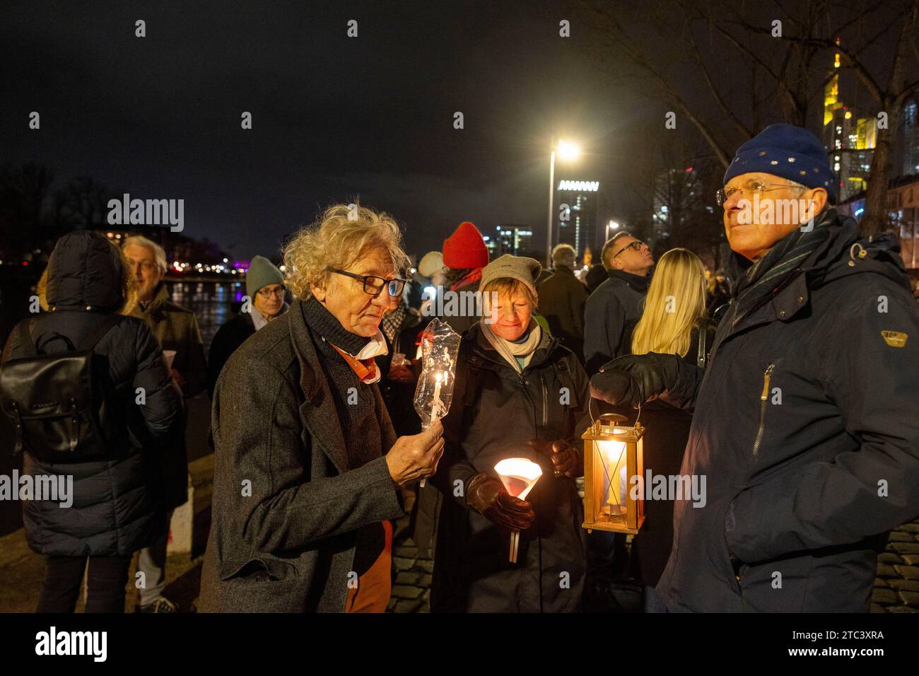 10. Dezember 2023, Hessen, Frankfurt/Main: Menschen nehmen an einer Lichterkette gegen Antisemitismus Teil. Frankfurts Kulturführer fordern eine Lichterkette entlang des Mainufers. Die katholische Rabanus-Maurus-Akademie, die Evangelische Akademie und zahlreiche andere kulturelle Einrichtungen der Stadt gehören zu den Sponsoren der Kampagne. Foto: Helmut Fricke/dpa Stockfoto