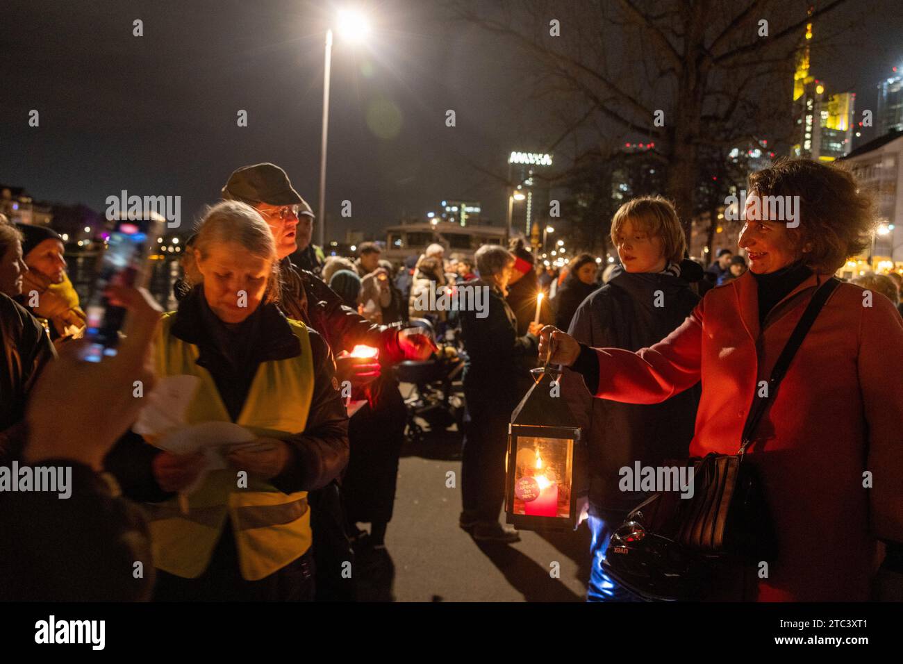 10. Dezember 2023, Hessen, Frankfurt/Main: Menschen nehmen an einer Lichterkette gegen Antisemitismus Teil. Frankfurts Kulturführer fordern eine Lichterkette entlang des Mainufers. Die katholische Rabanus-Maurus-Akademie, die Evangelische Akademie und zahlreiche andere kulturelle Einrichtungen der Stadt gehören zu den Sponsoren der Kampagne. Foto: Helmut Fricke/dpa Stockfoto