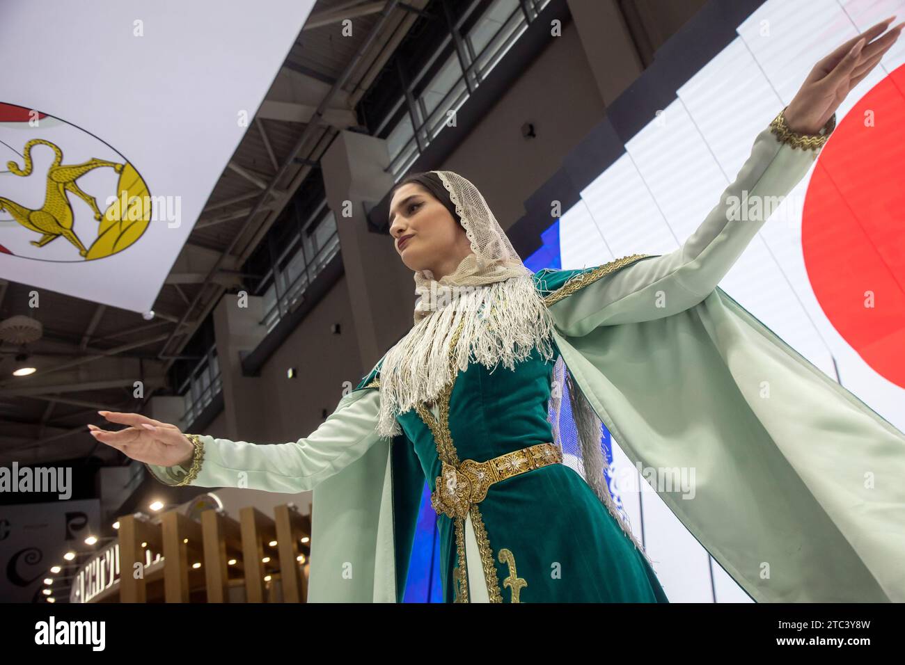 Moskau, Russland. Dezember 2023. Frau zeigt eine traditionelle Nationalkleidung am Stand der Republik Nordossetien während der internationalen Ausstellung und des Forums der Russia Expo im VDNKh-Ausstellungszentrum in Moskau Stockfoto