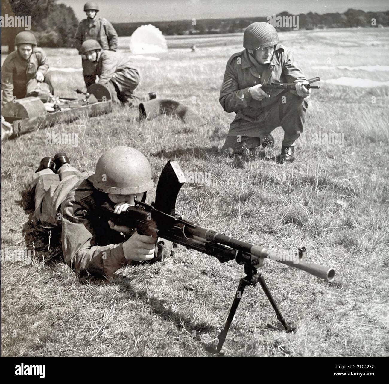 LUFTLANDEEINHEITEN britische Fallschirmjäger um 1943 mit einem Bren-Schützen an der Front und einem Soldaten an der rechten Seite mit einer Sten-Kanone. Gruppe dahinter mit Fallschirmkanister. Stockfoto