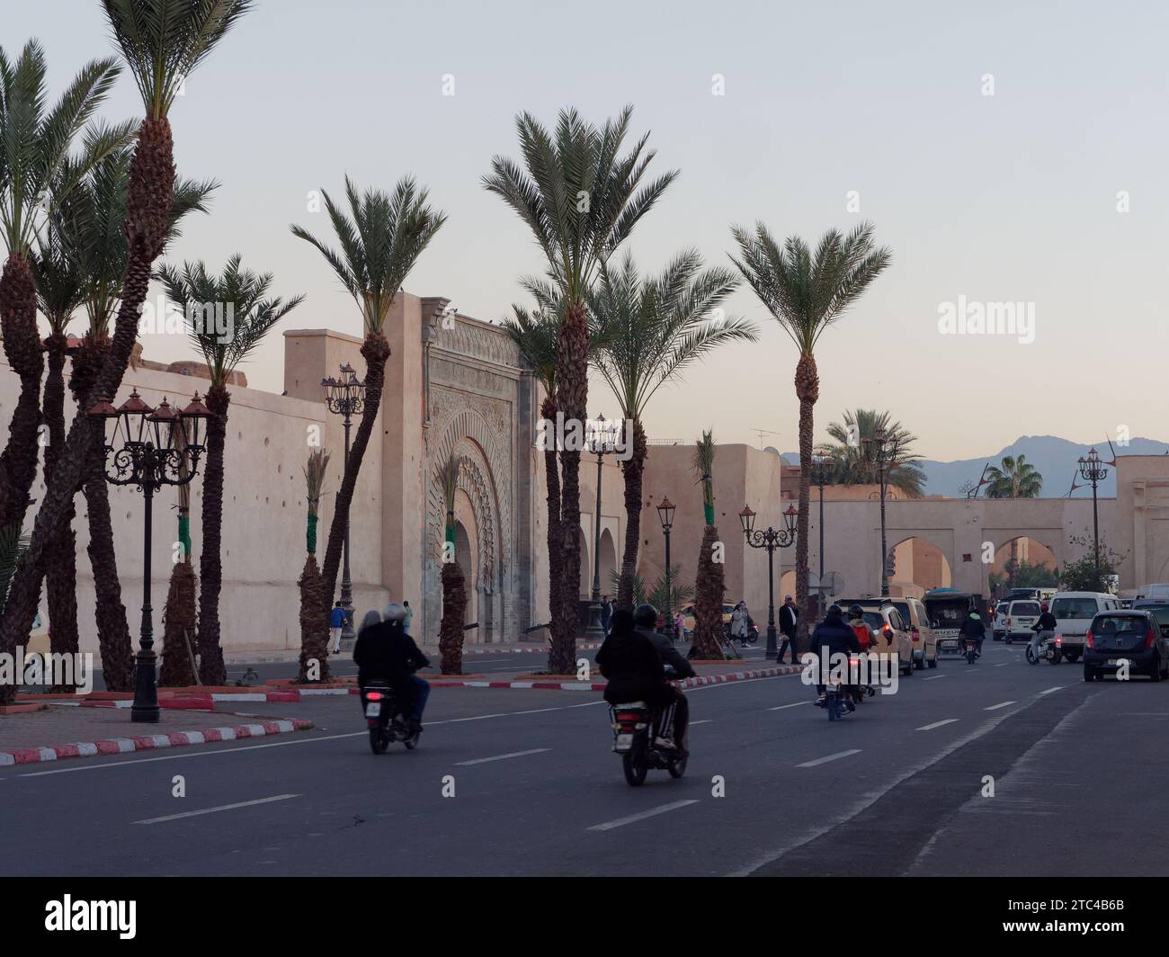Radfahrer fahren am Abend am Bab Agnaou (Tor Agnaou) in der Stadt Marrakesch aka Marrakesch, Marokko, am 10. Dezember 2023 vorbei Stockfoto