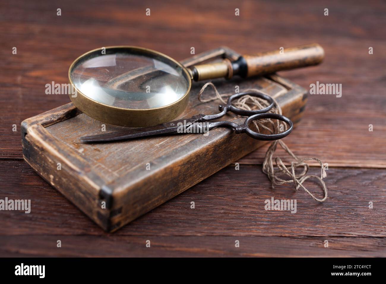 Antike Accessoires Holzkiste, alte Retro-Schere und Lupe. Nostalgischer Retro-sentimentaler Hintergrund. Stockfoto