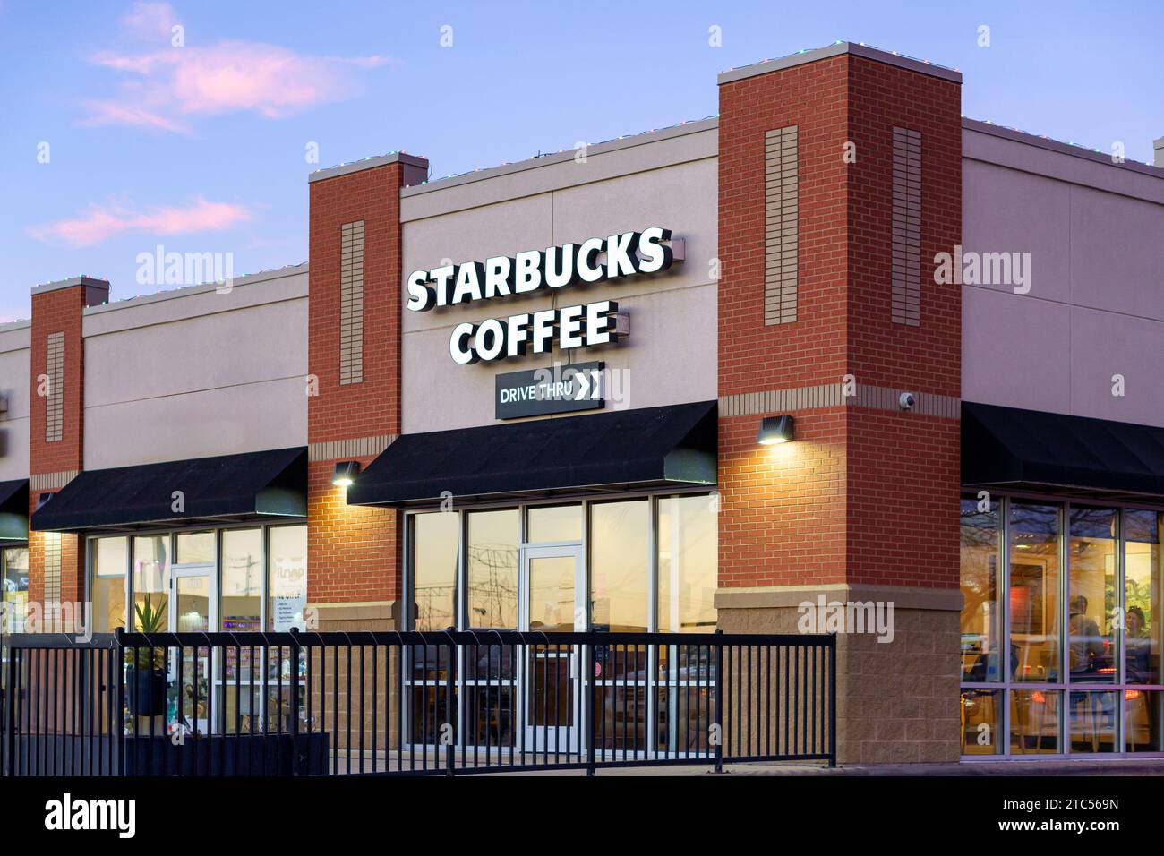STILLWATER, MN, USA - 7. DEZEMBER 2023: Starbucks Coffee Restaurant in der Abenddämmerung und Markenlogo. Stockfoto