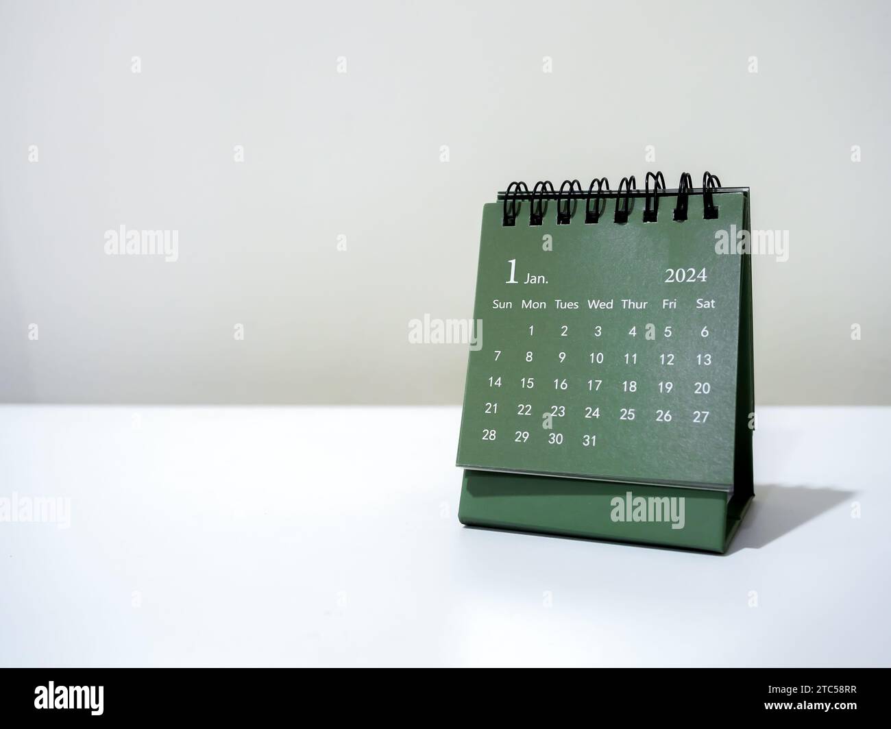 Ein Kalender-Schreibtisch für Januar 2024 für Organisatoren zur Planung und Erinnerung isoliert auf weißem Hintergrund mit Kopierraum, minimalem Stil. Grüne kleine Tischkalenda Stockfoto