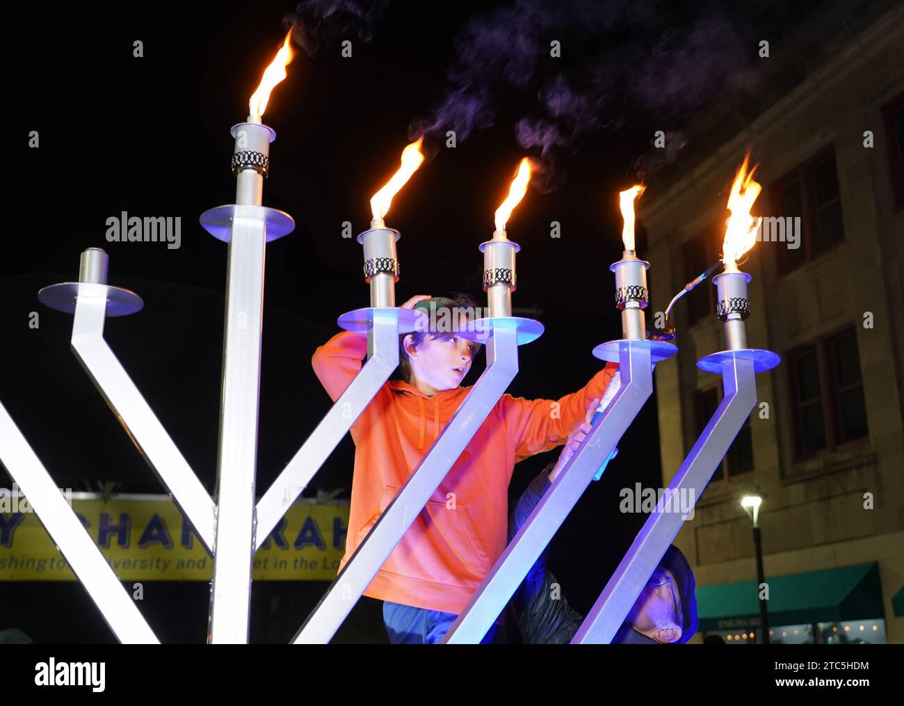 University City, Usa. Dezember 2023. Zack Doughty (12) steht auf einer Leiter und zündet am Sonntag, den 10. Dezember 2023, die Kerzen an der 15 Meter hohen Chanukah-Menora an. Foto: Bill Greenblatt/UPI Credit: UPI/Alamy Live News Stockfoto