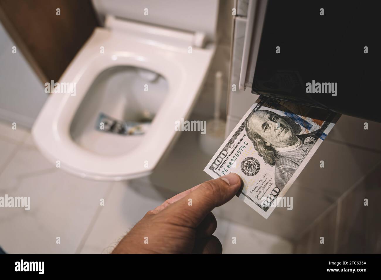 Geld in die Toilette spülen, Dollarscheine in die Toilette werfen, Verlustkonzept, Nahaufnahme, selektiver Fokus. Das Konzept sinnloser Geldverschwendung, Verlust, Usenale Stockfoto