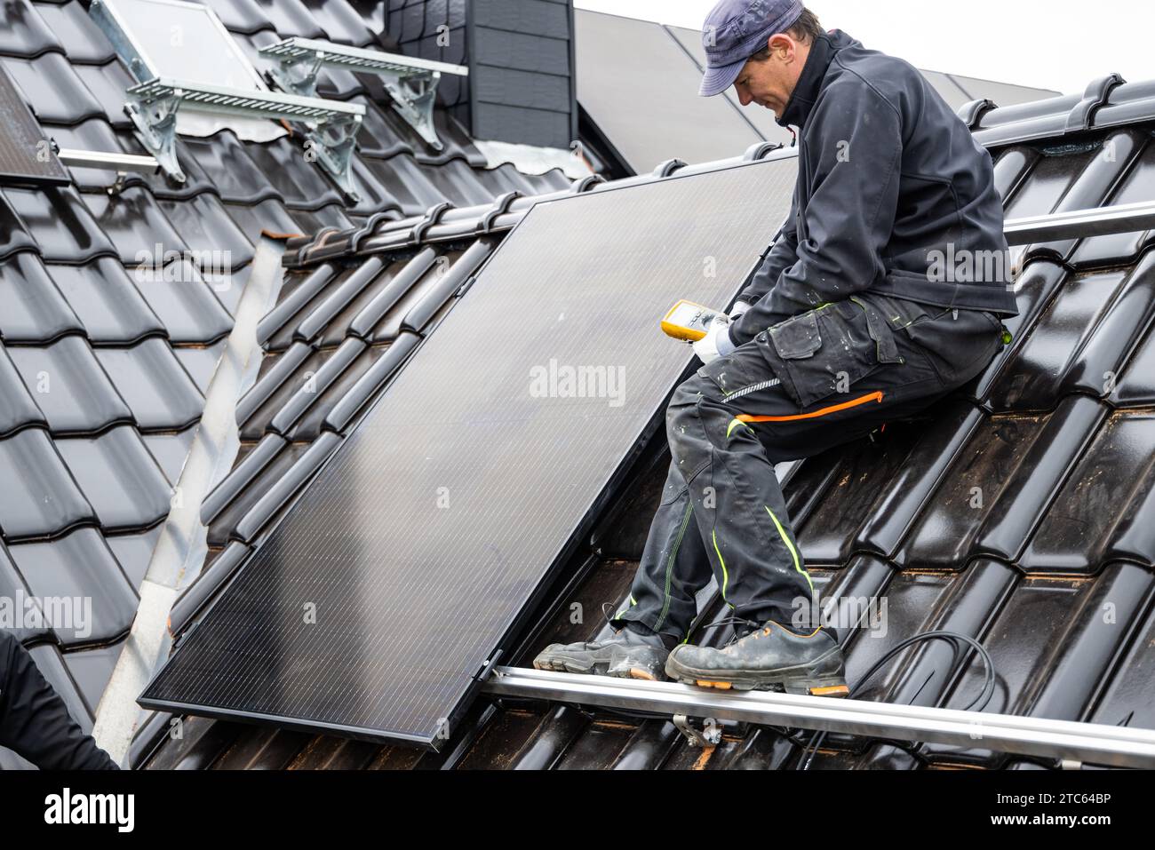 Techniker, der ein Multimeter für die Installation von Sonnenkollektoren verwendet Stockfoto