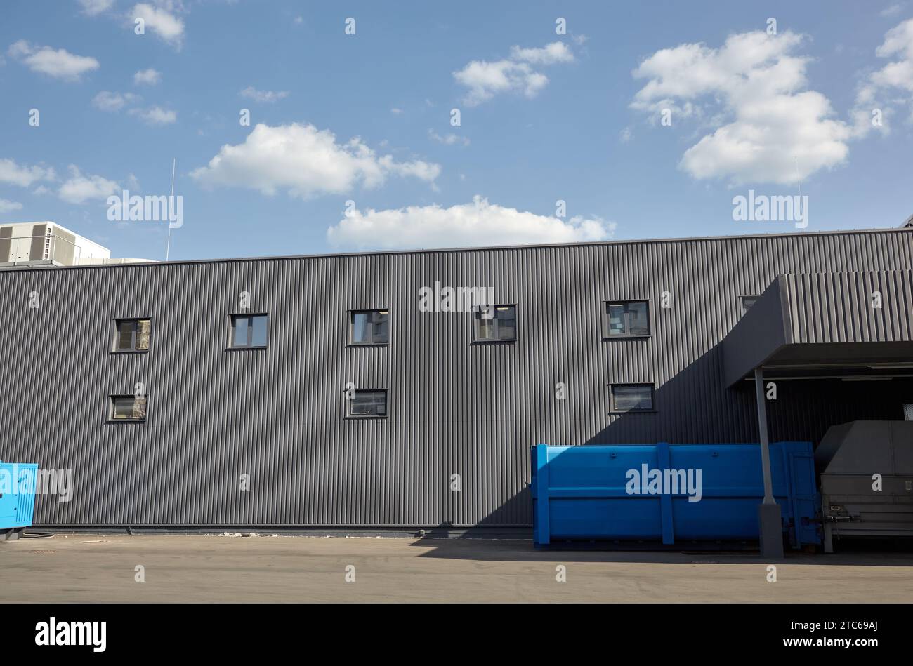 Laderampen eines Lagers. Wellblechlager Industriegebäude vor blauem, klarem Himmel Stockfoto