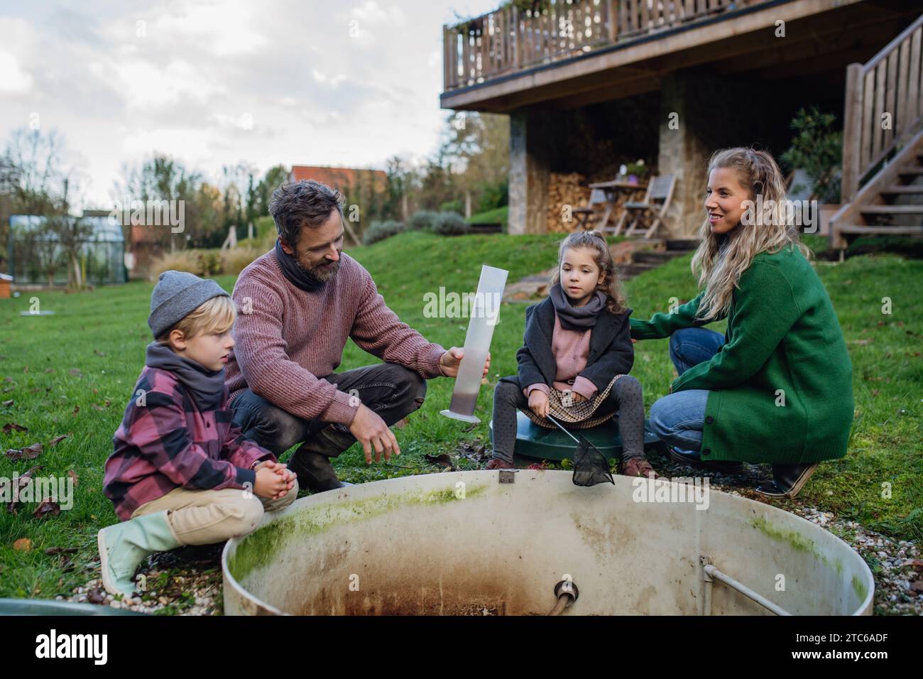 Die Familie, die die Wasserqualität in der Hauswasseraufbereitung überprüft. Konzept des nachhaltigen Familienlebens. Stockfoto