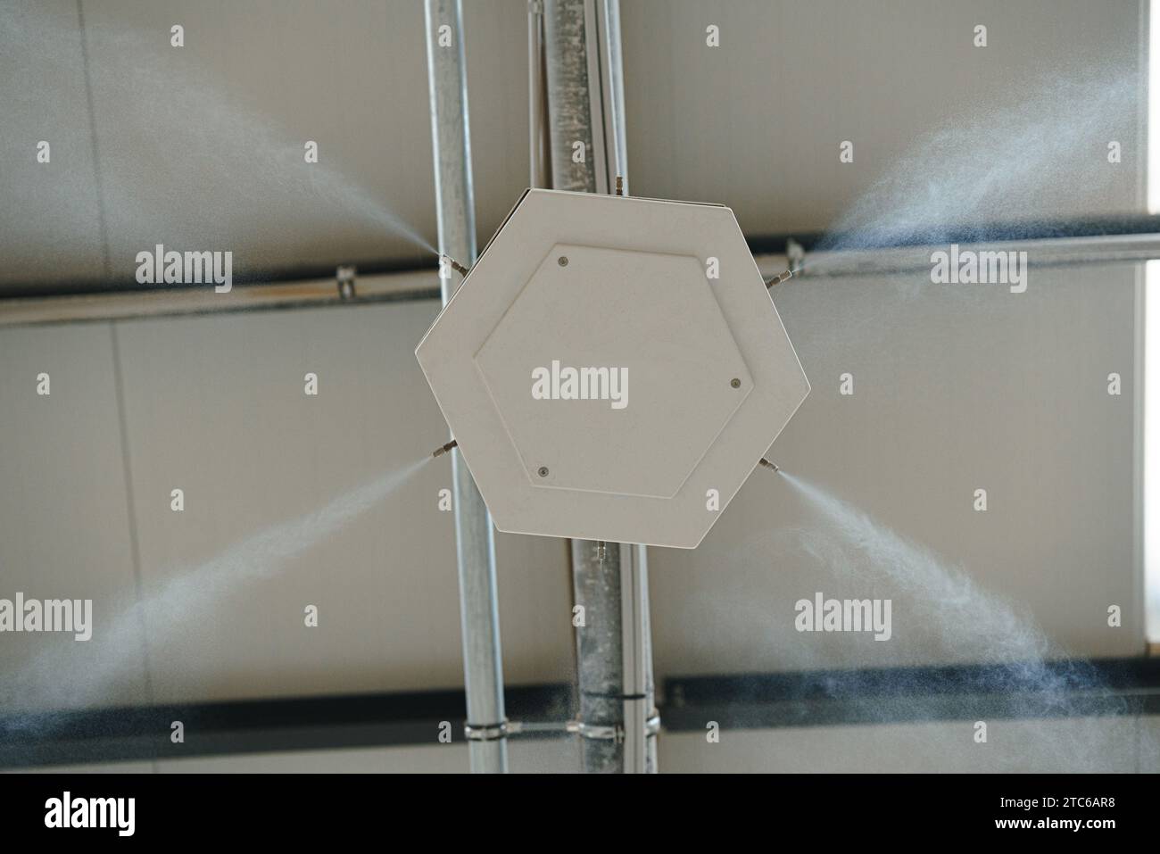 Industrielles Staubschutzsystem in modernen Fertigungswerken. Staubunterdrückung mit Wassernebel, wodurch feiner Wassernebel entsteht und Staubpartikel befeuchtet werden. Stockfoto