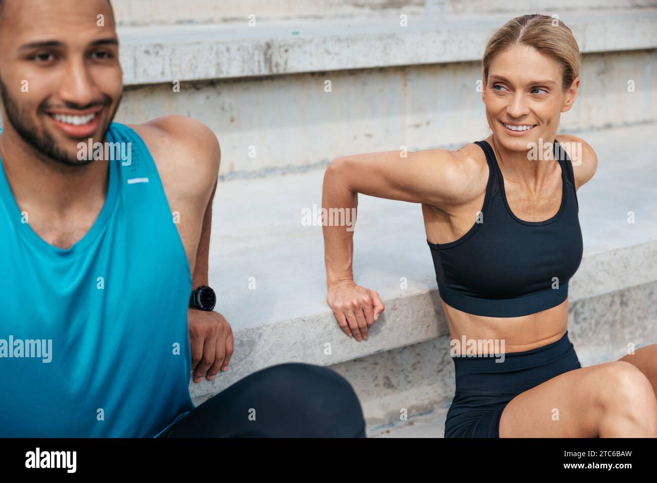 Sportliche Frau und Mann, die im Freien umgekehrte Liegestütze machen. Stockfoto