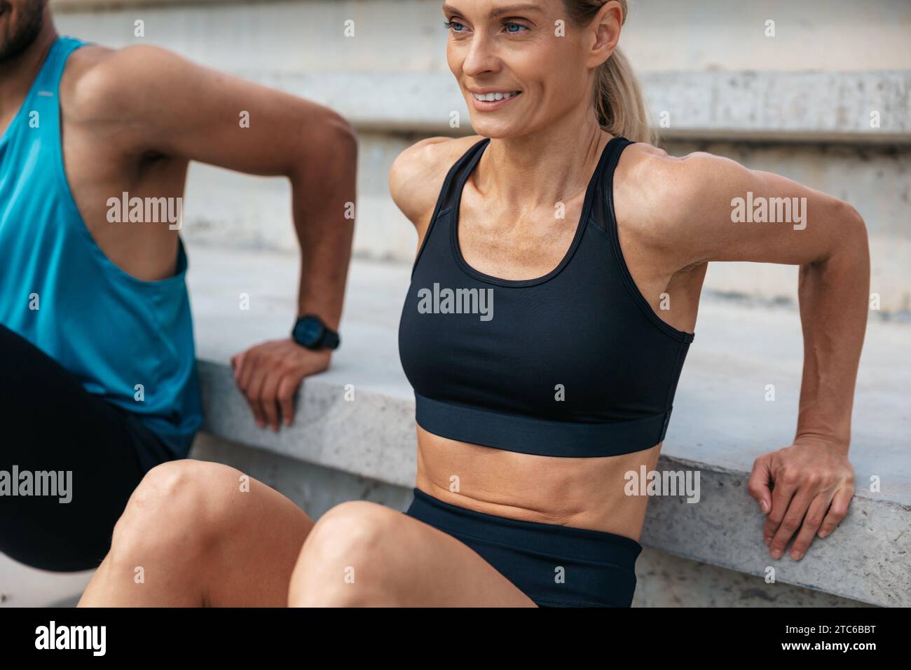 Sportliche Frau und Mann, die im Freien umgekehrte Liegestütze machen. Stockfoto