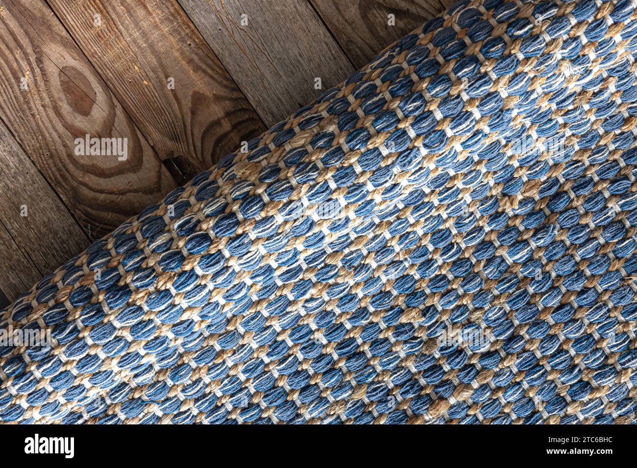 Handgewebter Teppich mit geometrischem Denim-Bereich auf Holzboden. Stockfoto