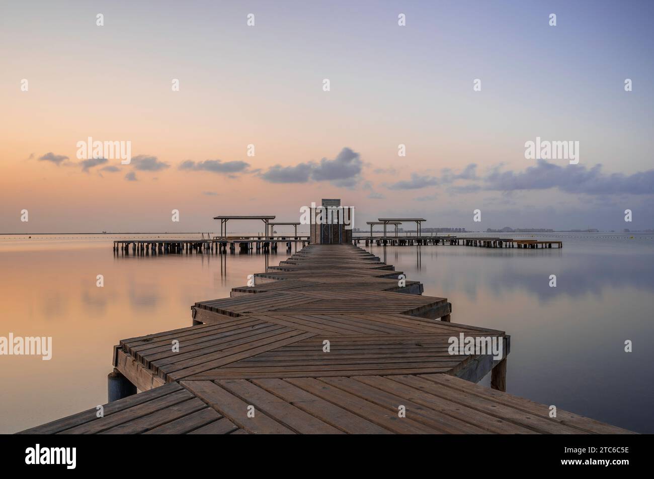 Wooden Jetty, der bei Sonnenaufgang in den Mar Menor in Südspanien reicht. Lange Exposition, um das Meer zu glätten Stockfoto