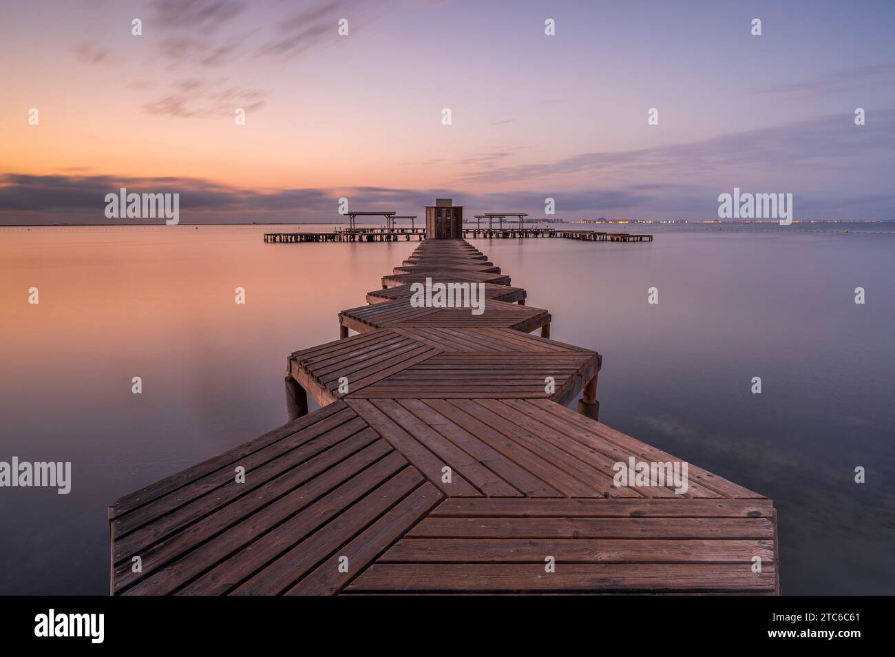 Wooden Jetty, der bei Sonnenaufgang in den Mar Menor in Südspanien reicht. Lange Exposition, um das Meer zu glätten Stockfoto