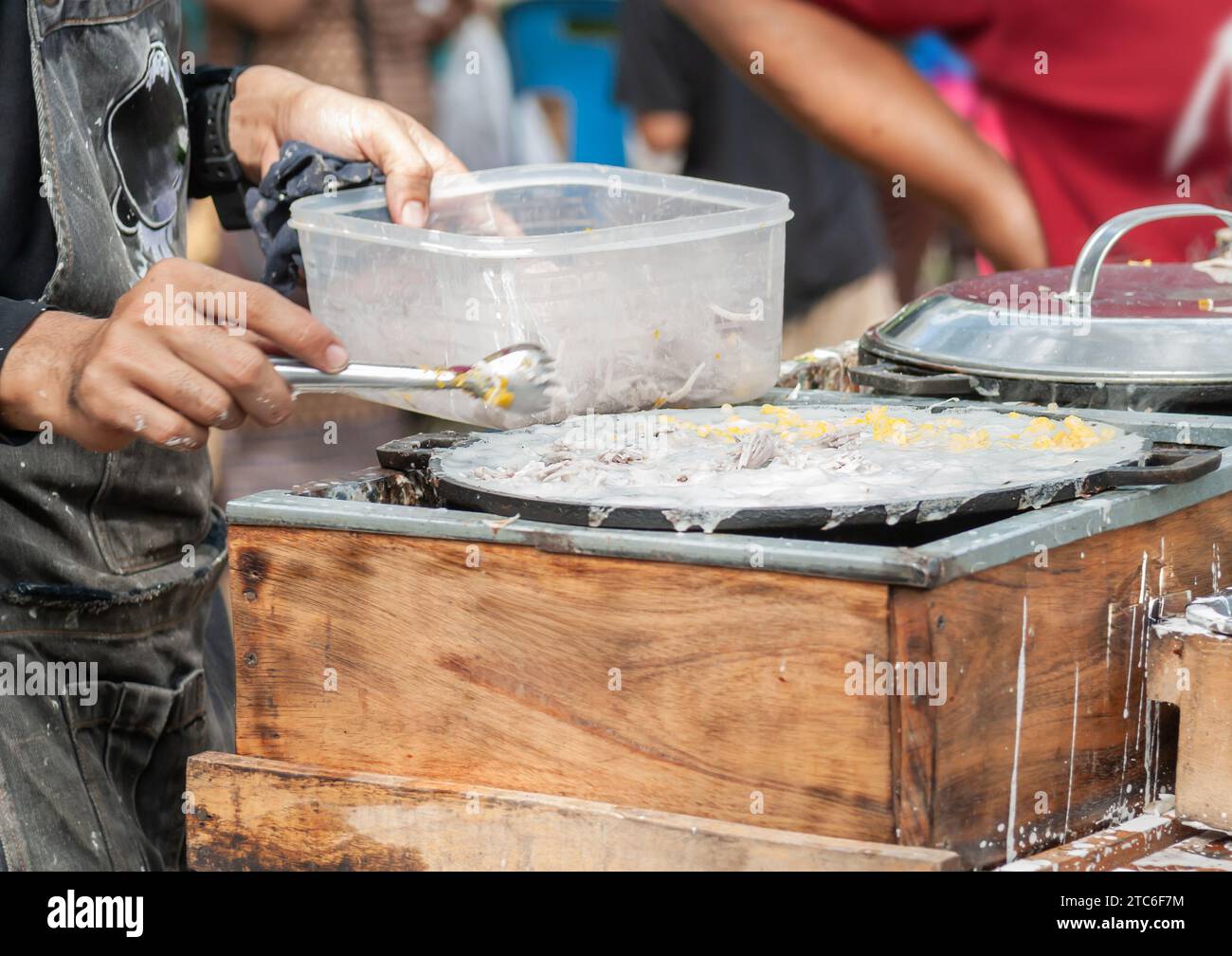 Thai Pancake, männliche Hände machen khanom krok traditionelle thailändische Desserts mit köstlichen Aromen sind bei Thailändischen und Touristen in der ganzen Welt beliebt Stockfoto