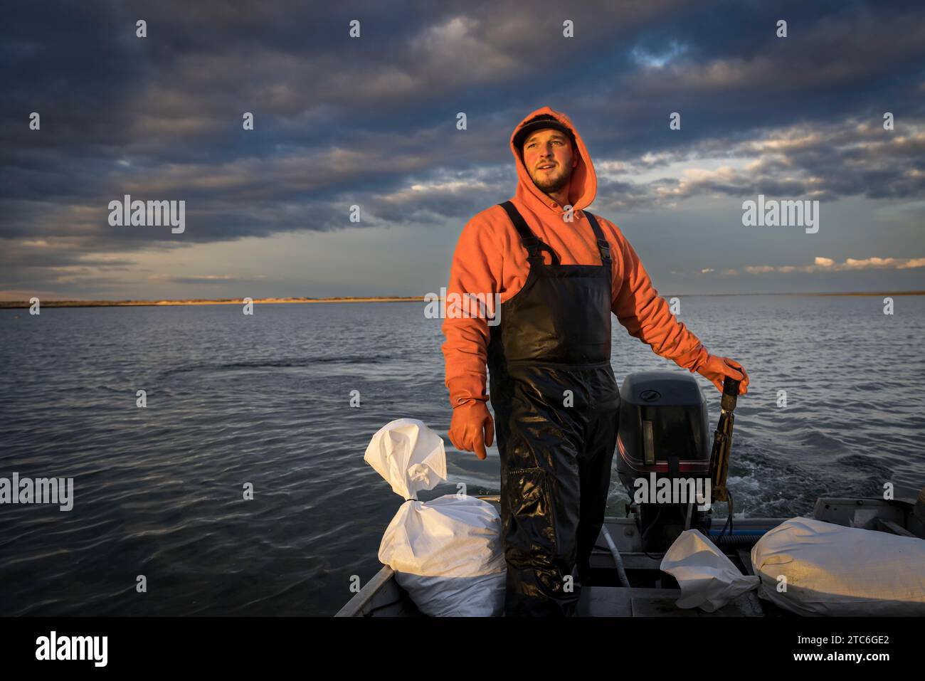 Kommerzieller Fischer, der ein Fischerboot mit stürmischem Himmel fährt Stockfoto