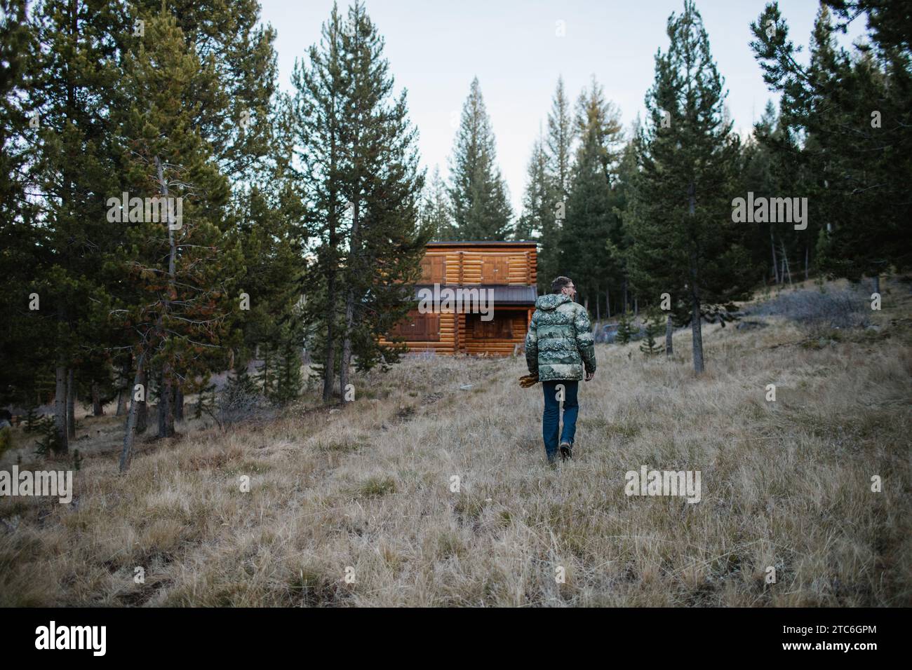 Ein Mann nähert sich einer rustikalen Hütte in der Wildnis von Idaho Stockfoto