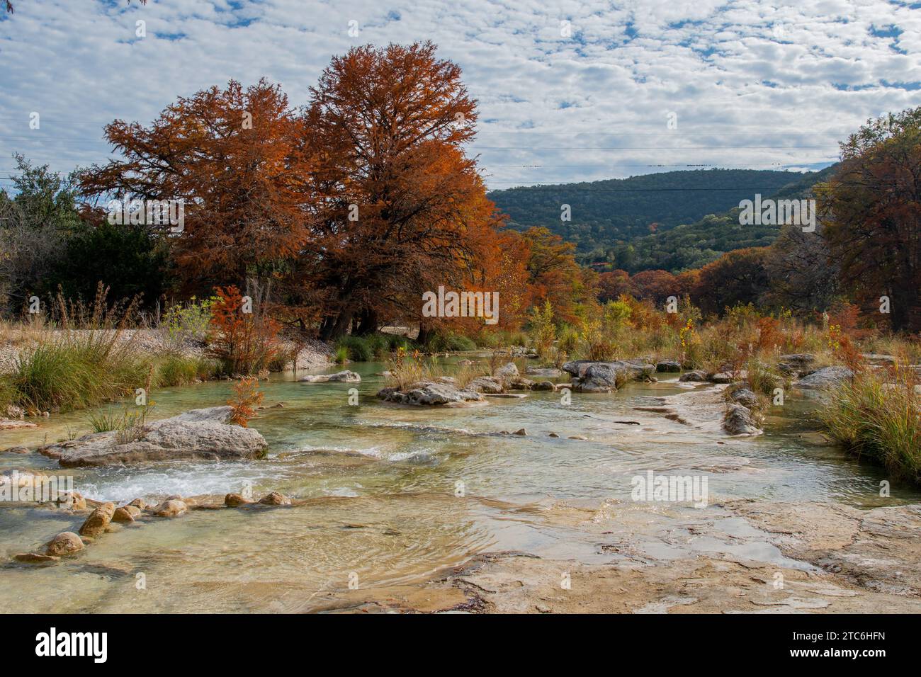 Friedlicher Herbstsee mit lebhaftem Laub und sanften Hügeln Stockfoto