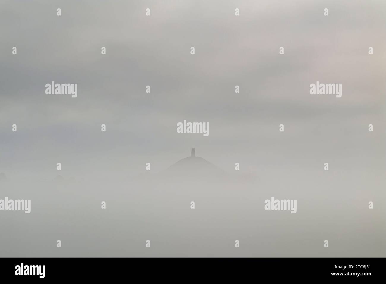 Glastonbury Tor taucht aus einem nebeligen Morgen auf, Somerset, England. Sommer (August) 2023. Stockfoto